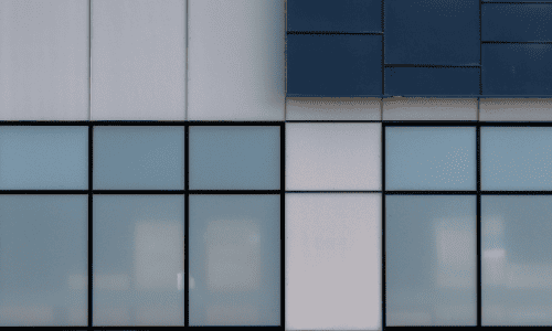 A commercial building with long narrow glass panel windows and black aluminium trim.