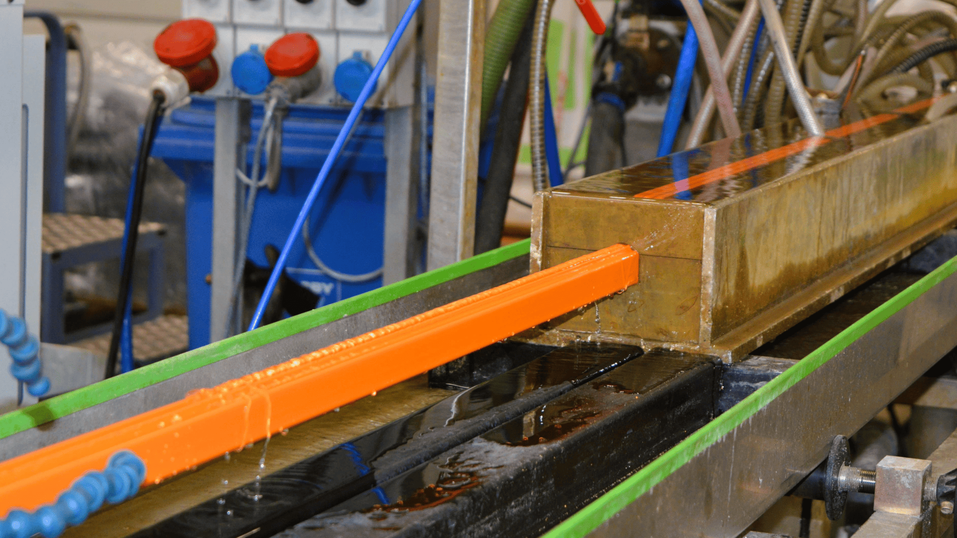 ORANGE PLASTIC PROFILE BEING EXTRUDED AT BWC PROFILES.
