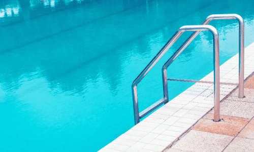 Outdoor swimming pool with aluminium ladder.